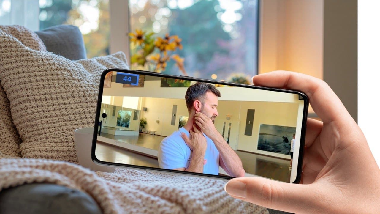 Hand hält ein Smartphone, auf dem eine geführte Übung des Programms läuft